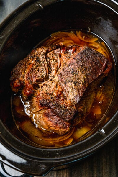 Beef pot roast cooked in the crock pot with onions and seasoned perfection until tender and juicy.