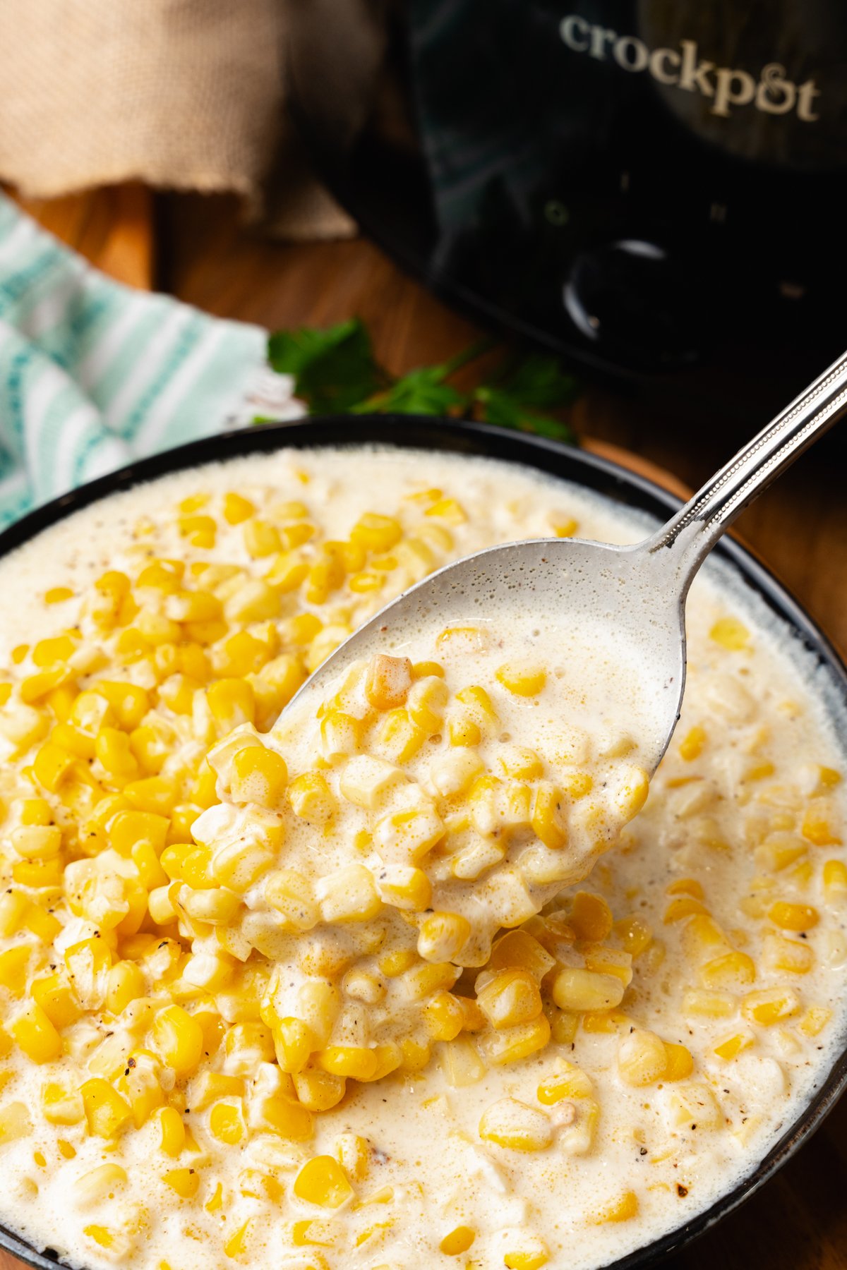 Silver spoon with a scoop of creamed corn that has been cooked in the crock pot.