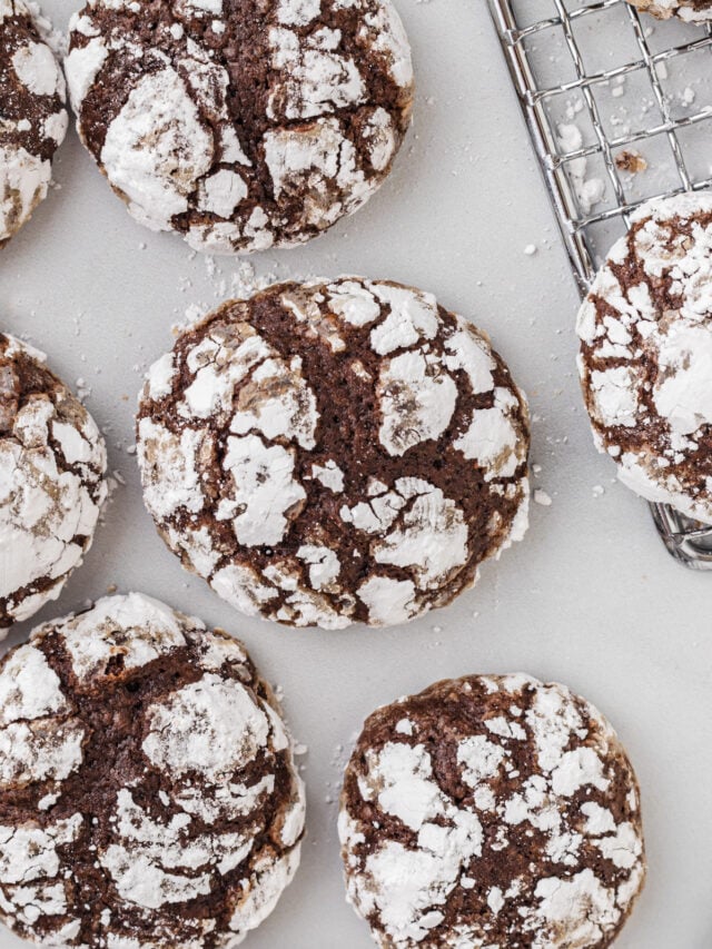 Crinkle cookies sitting on a table near a wire rack.