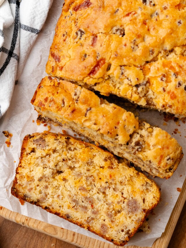 Sausage cheese bread cut into slices on top of a cutting board.