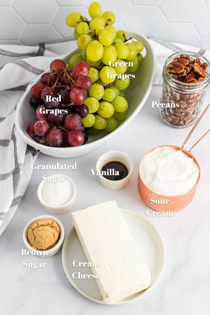 Cream cheese, souor cream, vanilla, sugar, brown sugar, red and green grapes in containers for Grape Salad.
