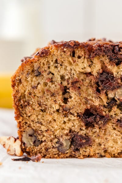 The corner of chocolate chip banana bread. the cross section has melty bits of chocolate and fluffy bread.