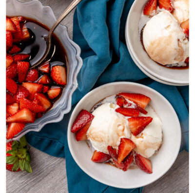 Bowl with red strawberries and balsamic glaze in it.