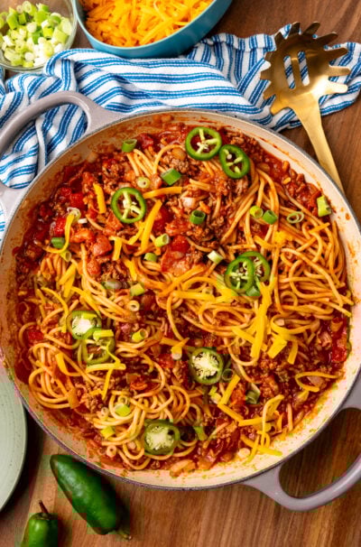 Cowboy Soaghetti made with ground beef bacon and other savory ingrediens topped with green onions and sliced jalapenos.
