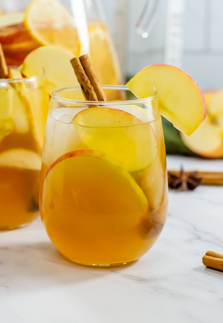 Apple Cider Sangria in a glass served with a cinnamon stick.