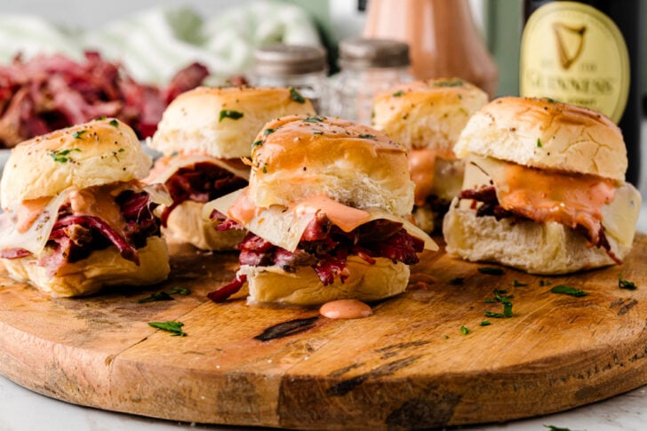Close-up of a corned beef Reuben slider pulled apart showing tender shredded corned beef and melted cheese.