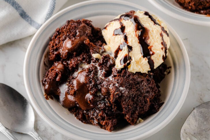 Southern Chocolate Cobbler served in a white bowl with vanilla ice cream melting on top, showing warm chocolate cake and sauce