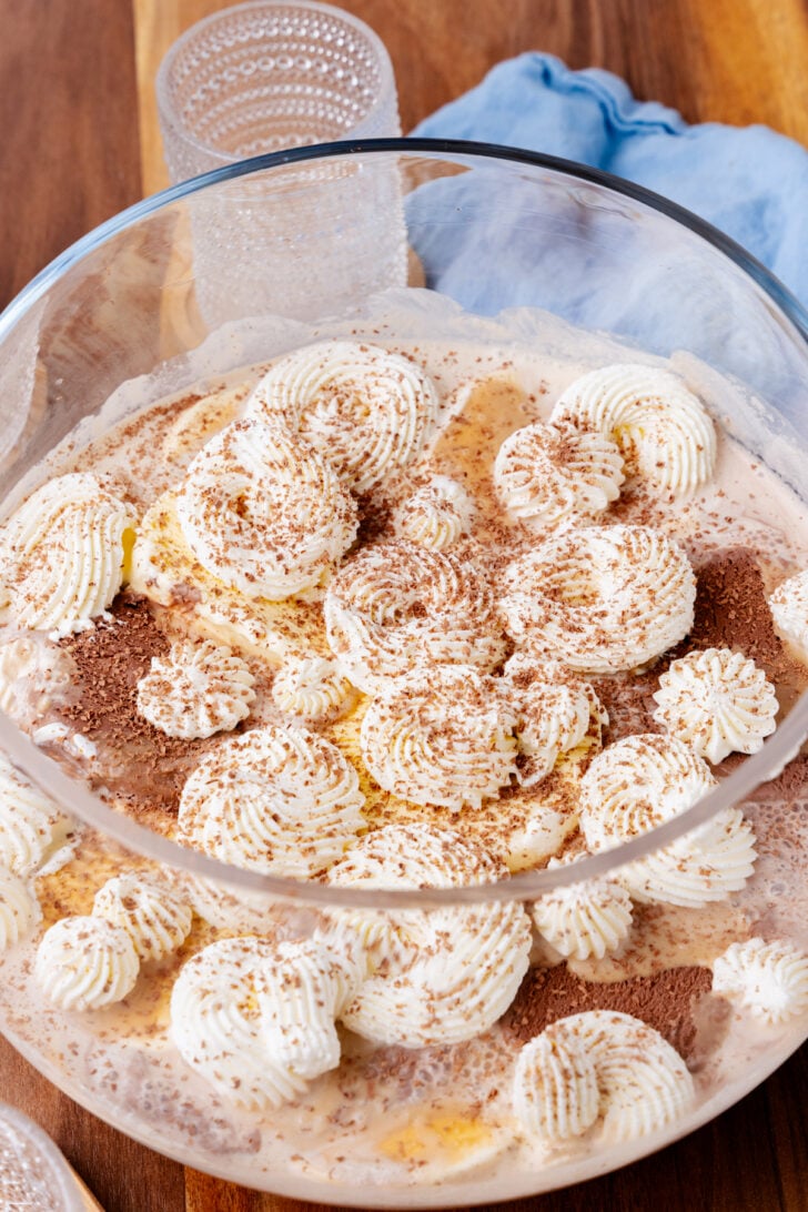 Tiramisu cookies dusted with cinnamon in a clear container with parchment paper, styled for Southern Coffee Punch recipe