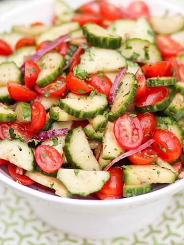 Tomato Cucumber Salad with homemade dressing in a white bowl.