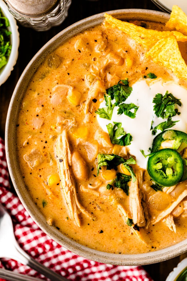 Creamy White Chicken Chili made with tender chicken, white beans, green chilies, and cream cheese, served in a bowl with toppings and a spoon — cozy Southern comfort food.