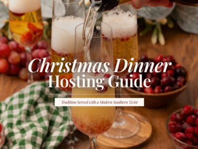 Champagne being poured into flutes with fresh cranberries, surrounded by bowls of cranberries and a green gingham napkin, with the title ‘Christmas Dinner Hosting Guide.’