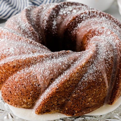Spice cake with cream cheese frosting sliced to show the moist cinnamon-spiced layers.