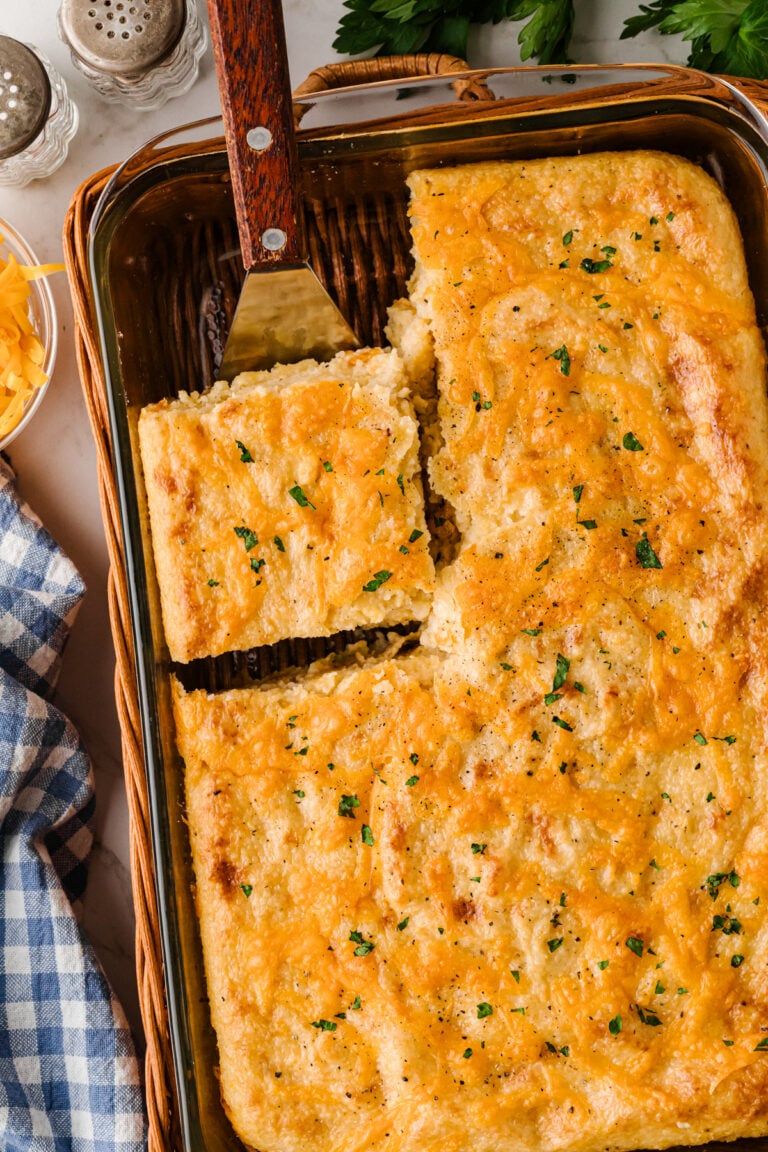 Creamy Southern baked cheese grits in a casserole dish with a golden cheesy top, a classic brunch side.