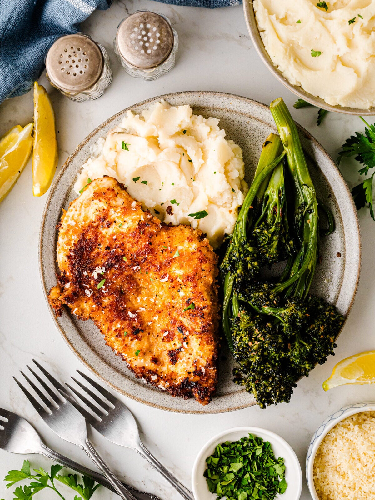 Crispy pan-seared chicken breast with creamy mashed potatoes and sautéed broccolini on a speckled plate for Easy Valentine's Day Dinner for