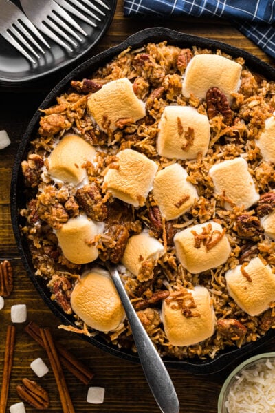 Sweet potatoes royale topped with a golden brown pecan streusel in a baking dish.
