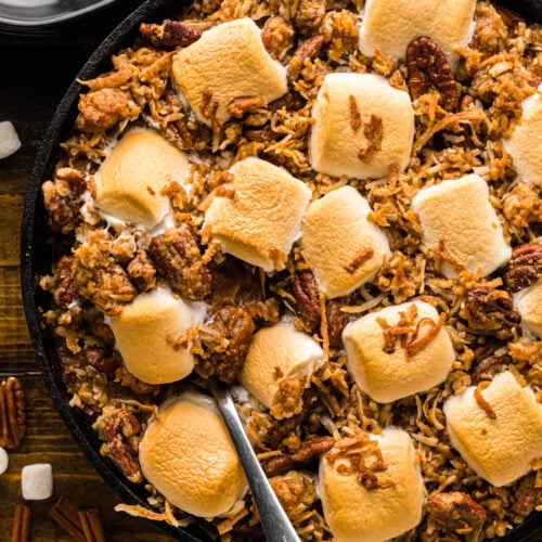 Sweet potatoes royale topped with a golden brown pecan streusel in a baking dish.