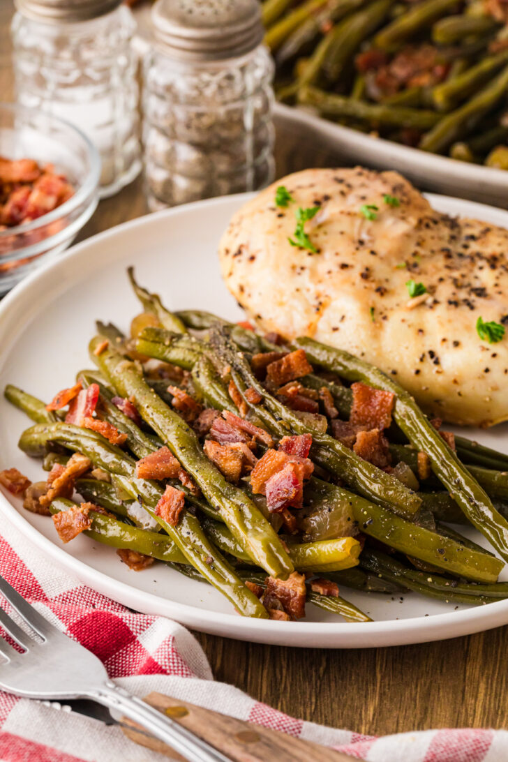 पके हुए चिकन की प्लेट को किनारे पर मेपल बेकन हरी बीन्स की भरपूर मदद से परोसा गया।