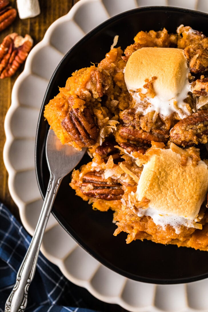 A serving of million dollar sweet potatoes on a plate showing the creamy filling and crunchy topping.