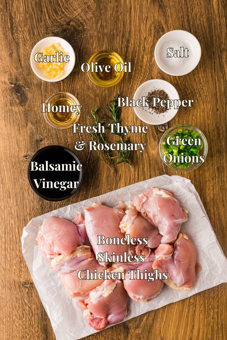 हनी मैरीनेड चिकन जांघें ताजा थाइम और लहसुन और शहद के साथ मेंहदी के साथ चमकदार गहरे बाल्समिक में भिगोने के लिए तैयार हैं।