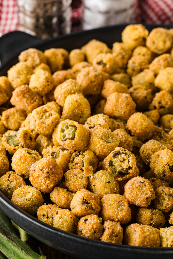 Fried okra piled in a black skillet, close-up view.
