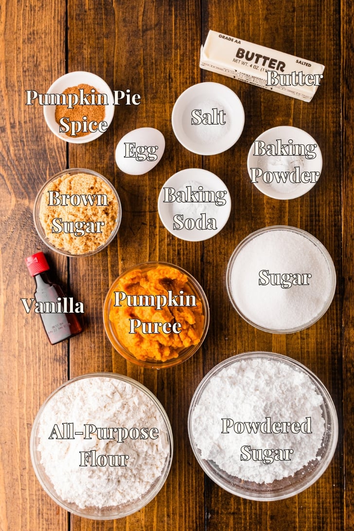 Labeled ingredients for pumpkin crinkle cookies: pumpkin puree, flour, sugar, brown sugar, powdered sugar, butter, egg, vanilla, pumpkin pie spice, baking soda, baking powder, and salt.