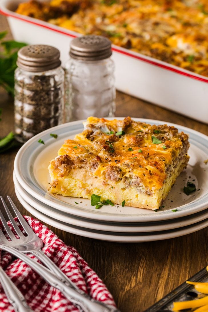 http://asouthern-soul.blogspot.com Egg and sausage breakfast casserole with cheddar cheese and a crescent roll crust served on a white plate.